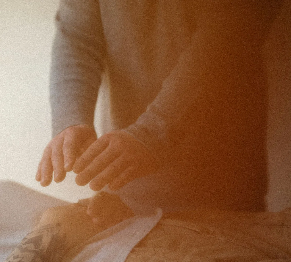 Hands held above a client during a Reiki session